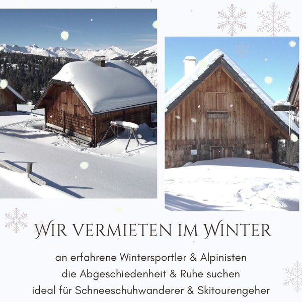 The wooden Alpine Hut covered in snow, set in a winter mountain landscape.
