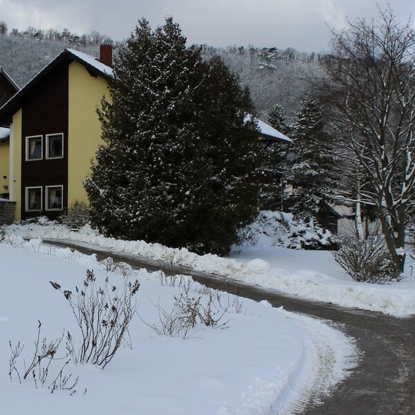The Farm House exterior during winter, surrounded by snow and featuring a cleared access path.
