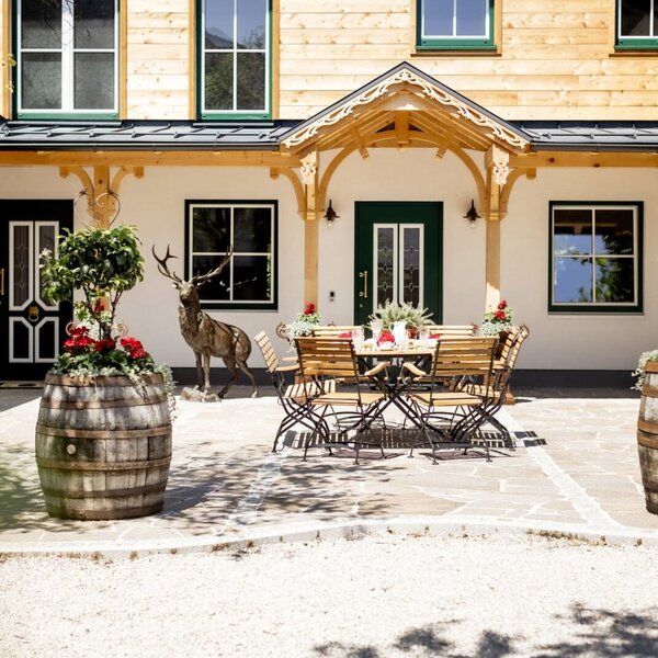 Die Terrasse der Appartements mit Außensitzgelegenheiten und dekorativen Pflanzen in Weinfässern. | © Urlaub am Bauernhof Oberösterreich / Bettina Gangl