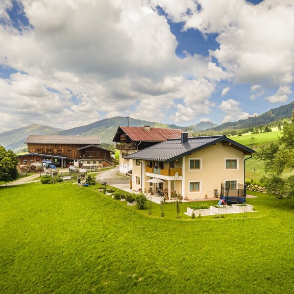 Das einladende Bed and Breakfast umgeben von einer weitläufigen grünen Wiese und einer malerischen Bergkulisse.