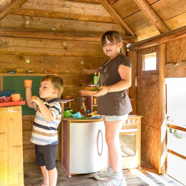 Ein gemütliches Holzspielhaus auf dem Bauernhof mit einer gut ausgestatteten Spielküche für die kleinen Gäste.