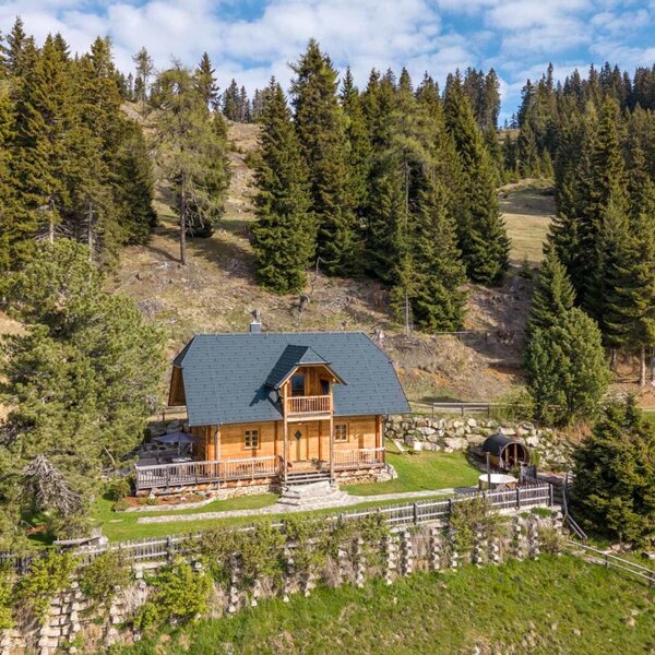 Außenansicht der Wildinghütte. Ein Holzhaus mit Terrasse und Fasssauna, gelegen auf der Alm. (c) Elisabeth Fröhlich Photography