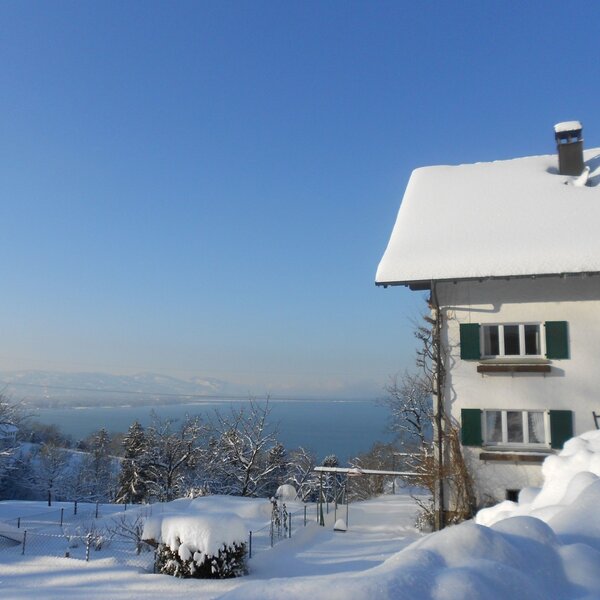 The snow-covered Farm House offers a clear view of the lake and distant mountains.